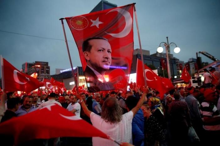 A supporter holds a flag depicting Turkish President Tayyip Erdogan during a pro-government demonstration in Ankara