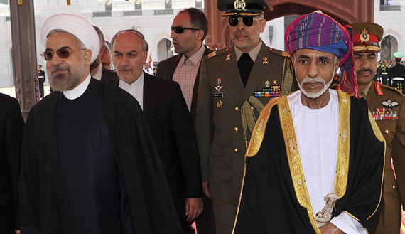 Oman's Sultan Qaboos bin Said walks with Iran's President Hassan Rouhani upon Rouhani's arrival in Muscat